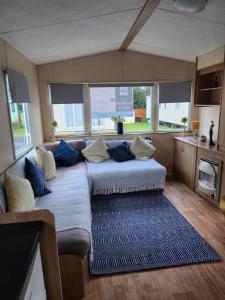 sala de estar con sofá y almohadas azules en regent bay, en Morecambe