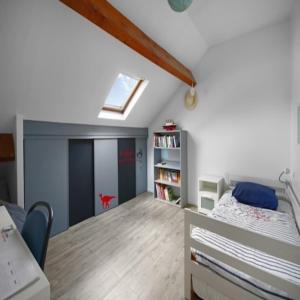 een slaapkamer met een bed en een boekenplank bij Maison Bezons: Confort & Jardin in Bezons