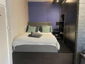 a bedroom with a bed with a purple wall at Central Studio on Main in Cape Town
