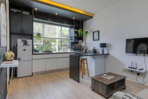 een keuken met een koelkast en een tafel in een kamer bij Central Studio on Main in Kaapstad