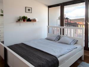 a white bed in a room with a window at Cozy Apartment nearby Arena in Prague