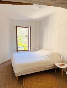 ein Schlafzimmer mit einem großen Bett und einem Fenster in der Unterkunft Maison au coeur du village jusqu'à 7 personnes in Cotignac