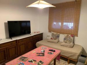 een woonkamer met 2 bedden en een flatscreen-tv bij Casa Rural Oropesa in Villanueva del Ariscal