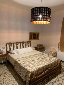 een slaapkamer met een bed en een kroonluchter bij Casa Rural Oropesa in Villanueva del Ariscal