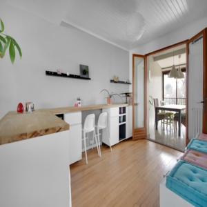 a kitchen and living room with a table and chairs at Maison Bezons: Confort & Jardin in Bezons