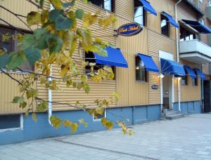 un restaurant avec des auvents bleus sur le côté d'un bâtiment dans l'établissement Park Hotell, à Luleå