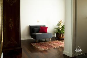 - Silla con almohada roja en la sala de estar en L'AmElie - Elegante Suite, en Stra