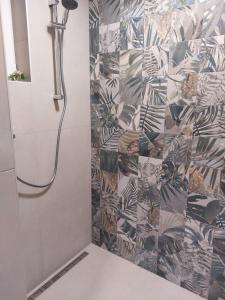 a shower in a bathroom with a tile wall at Ubytovanie v Bojniciach - Apartmánový dom Bojnice in Bojnice