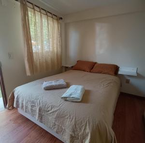 a bedroom with a bed with two towels on it at Hostal Casona Don Ranulfo in Peñas