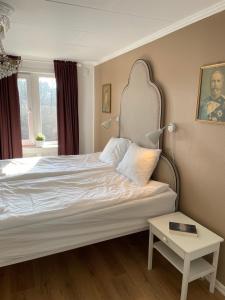 een slaapkamer met een bed met een hoofdeinde en een tafel bij Villa Högby in Löttorp