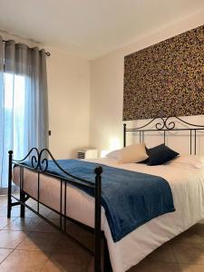 Un dormitorio con una cama grande con una manta azul. en MiriAle House Aeroporto Fiumicino, en Fiumicino