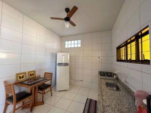 Campo Novo do ParecisにあるCasa confortável área centralのテーブルと白い冷蔵庫のあるキッチン