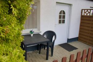 a small table and chairs in front of a door at gemütlicher Gartenbungalow (Nr. 1) mit Terrasse - Strandvogtei Sellin in Ostseebad Sellin