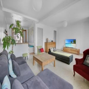 een woonkamer met een bank en een tafel bij Maison Bezons: Confort & Jardin in Bezons