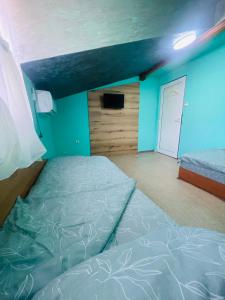1 dormitorio con cama y pared azul en Вила Маца, en Sapareva Banya