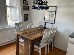 a dining room with a wooden table and chairs at romantische Ferienwohnung Sachsenhof 2 in Klingberg