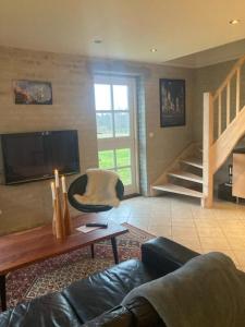 a living room with a couch and a table at Bøllingsø Feriehus in Silkeborg