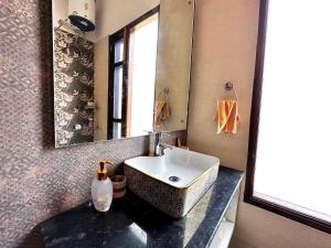 a bathroom with a sink and a mirror at Luxury Villa with Free Breakfast - RnR Manor in Kālka