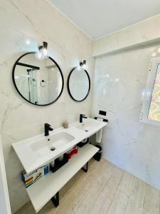Baño blanco con lavabo y 2 espejos en Imperium Apartamentos Centro Parking Gratis, en Mérida
