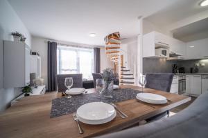 a kitchen and dining room with a table with plates and glasses at Apartmán Andy Riviera 503-10 Lipno Home in Lipno nad Vltavou