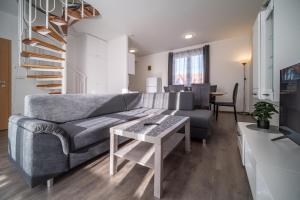 - un salon avec un canapé gris et une table dans l'établissement Apartmán Andy Riviera 503-10 Lipno Home, à Lipno nad Vltavou