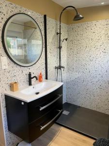 een badkamer met een wastafel en een douche met een spiegel bij Jolie maison à Equihen-Plage in Équihen-Plage