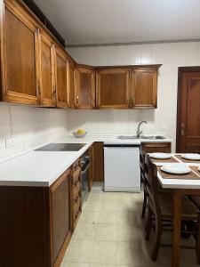 a kitchen with wooden cabinets and a table in it at El Paseíllo in Priego de Córdoba +17 photos