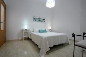 コニル・デ・ラ・フロンテーラにあるApart ConiL Benaventの白いベッドルーム(ベッド1台、椅子付)