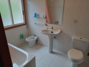 łazienka z toaletą, umywalką i wanną w obiekcie Pensión O Regato w mieście Redondela