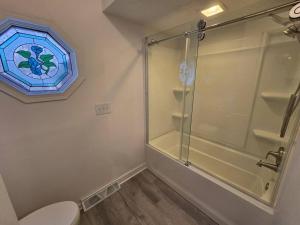 a bathroom with a glass shower and a toilet at White Tail Run At Heron Hill Retreat Hot Tub Lake! in Streetsboro