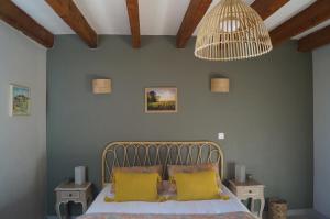 sypialnia z łóżkiem z 2 żółtymi poduszkami w obiekcie Les Prés d'Allerey 