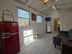 ein Wohnzimmer mit einem roten Kühlschrank und einem Sofa in der Unterkunft White Tail Run At Heron Hill Retreat Hot Tub Lake! in Streetsboro