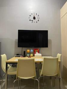 a dining room table with chairs and a clock on the wall at Grass residence tower3 30th Floor in Manila