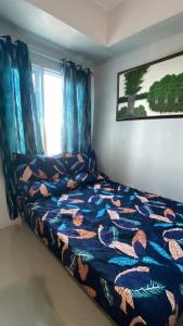 a bedroom with a bed with a fish themed blanket at Grass residence tower3 30th Floor in Manila