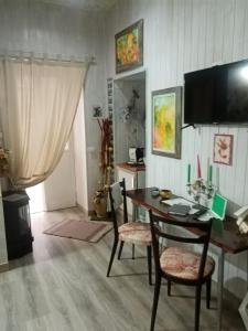 a dining room with a table and chairs and a television at La Casetta Di Anna in Castel Lagopesole