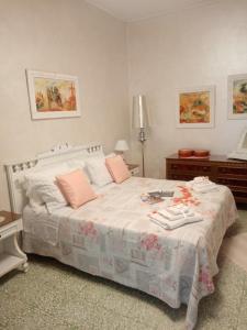 1 dormitorio con 1 cama blanca grande con almohadas rosas en La Casetta Di Anna en Castel Lagopesole