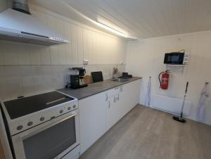 a kitchen with white cabinets and a stove top oven at Holmset Camping and Fishing in Namdalseid