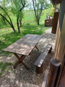 a wooden picnic table and a bench next to a building at Gospodarstwo Agroturystyczne Rowerowa Przystań "Jankesówka" in Lidzbark Warmiński