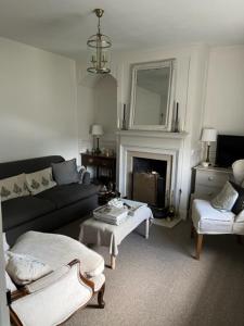 sala de estar con sofá y chimenea en Old Cross Cottage, en Penrith