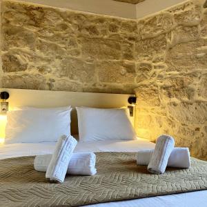 1 dormitorio con 1 cama grande con almohadas blancas en Serenity Stone House, a Blissful Retreat en Petrokefalo