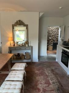 Habitación con mesa, mesa y cocina. en Old Cross Cottage, en Penrith