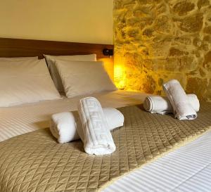 Una cama con toallas enrolladas encima. en Serenity Stone House, a Blissful Retreat en Petrokefalo