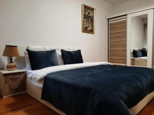 - une chambre avec un grand lit et des oreillers bleus dans l'établissement Prishtina Central Apartment, à Pristina