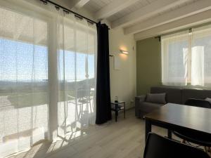 salon ze stołem i dużym oknem w obiekcie Villa Nina - Apartments & Relax w mieście Caprino Veronese