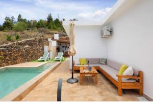 sala de estar con sofá y piscina en Casa Valista en Tijarafe