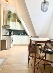 een keuken met witte kasten en een tafel en stoelen bij Hotspot 83 in Alkmaar