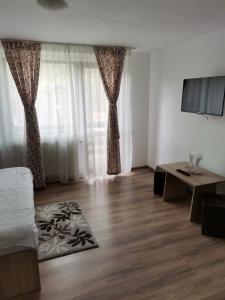 a living room with a bed and a table at VILA ALICE & DENIS in Bran