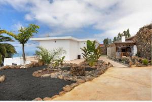 a white house with a yard with rocks at Casa Valista in Tijarafe