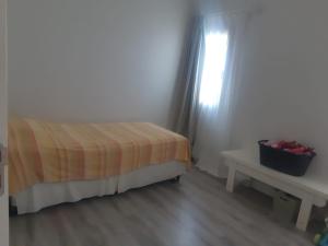 a bedroom with a bed and a table and a window at Hermosa casa en barrio privado de 2 habitaciones in Concepción del Uruguay