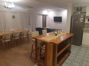 a kitchen and dining room with a table and a refrigerator at Hermosa casa, calidad y tranquilidad garantizada in Concepción del Uruguay